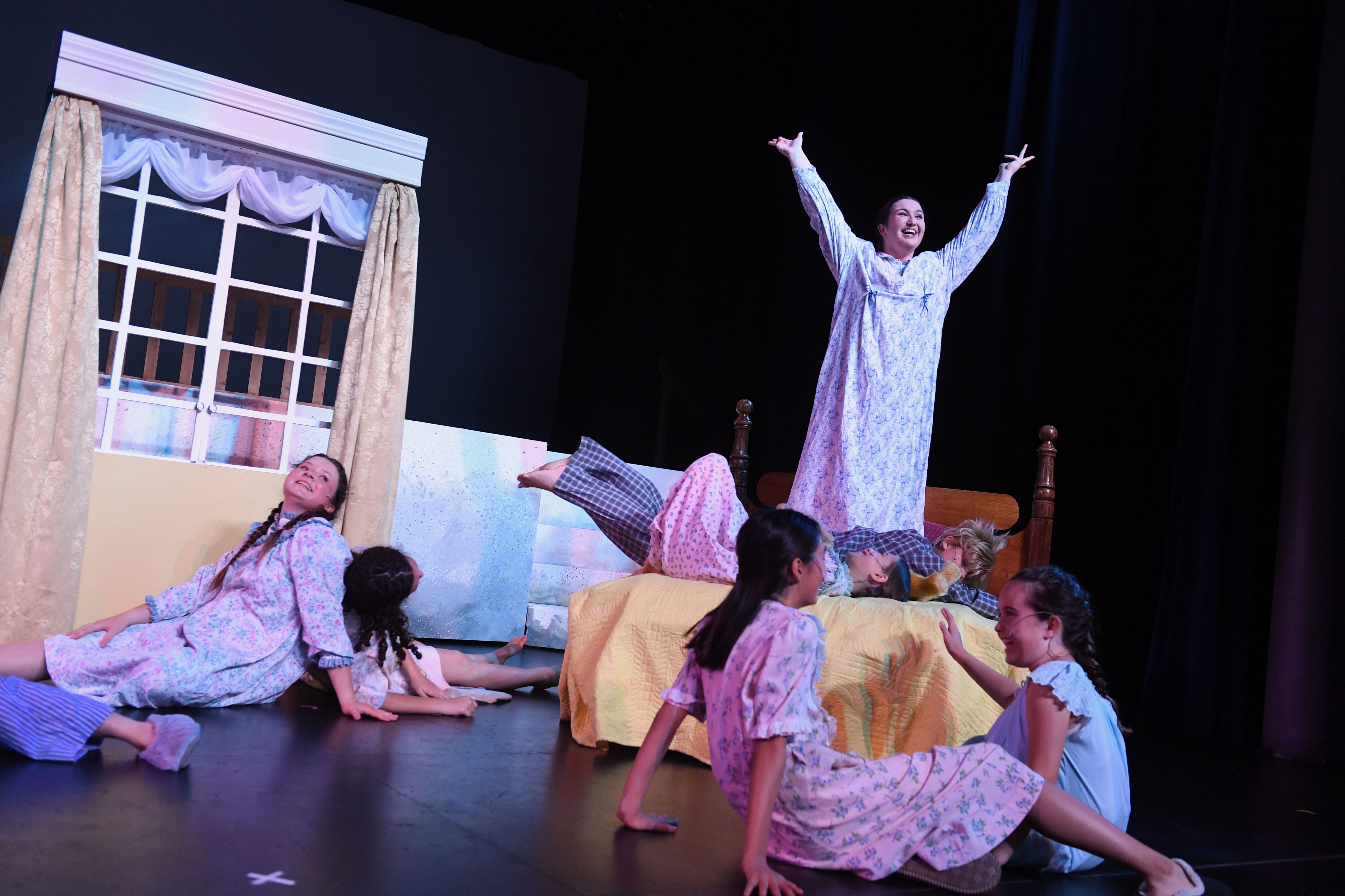 Maria stands on the bed